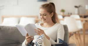 woman reading a parenting book smiling