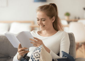 woman reading a parenting book smiling