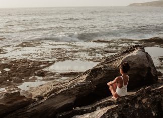 woman sitting on a rock experiencing pandemic burnout