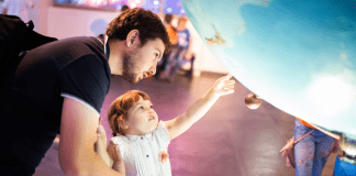 parent and child looking at a globe at a museum on a rainy day
