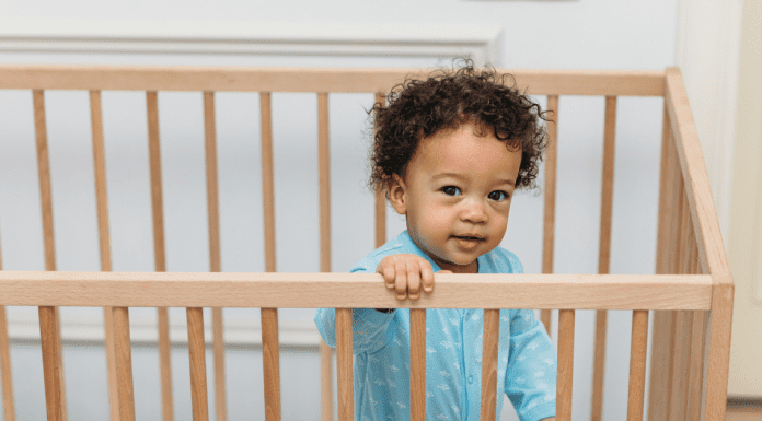 toddler standing in his crib, not sleeping because he is ready to drop naps