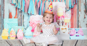 baby sitting celebrating her birthday as she turns one