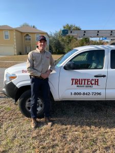 Trutech wildlife service specialist standing next to his truck