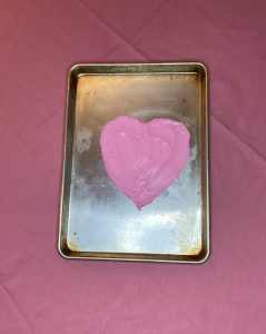 frosting spread in a heart shape on the baking sheet for easy valentine's dessert board.