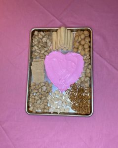 cookies and treats poured around the frosting heart for the easy valentine's dessert board